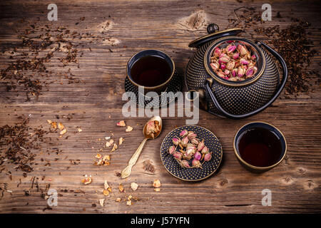 Ghisa giapponese teiera con foglie di tè e tazze su un handmade tappetino  di granturco Foto stock - Alamy