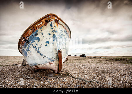 Unico abbandonato vecchie barche da pesca sulla spiaggia di ghiaia. Dungeness, Inghilterra Foto Stock