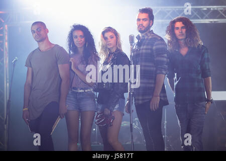 Ritratto di musicisti in piedi insieme sul palco in discoteca Foto Stock