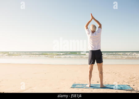 Vista posteriore del senior uomo stiro a spiaggia Foto Stock