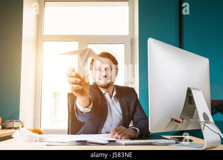 Imprenditore gettando aeroplano di carta Foto Stock