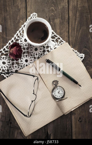 Vintage orologio da tasca, vecchio libro e caffè sul tavolo in legno Foto Stock