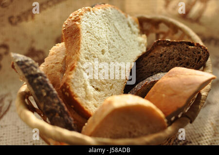 Un assortimento di pane affettato in un cesto di vimini vicino. Messa a fuoco selettiva. Foto Stock