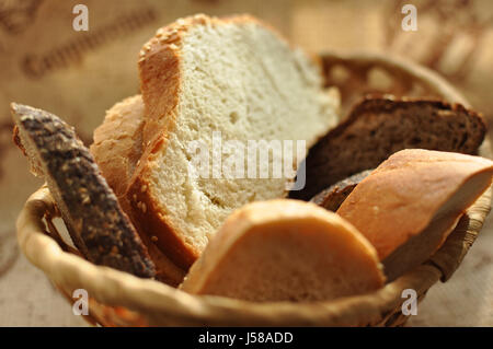 Un assortimento di pane affettato in un cesto di vimini vicino. Messa a fuoco selettiva. Foto Stock