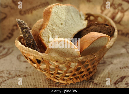 Un assortimento di pane affettato in un cesto di vimini vicino. Messa a fuoco selettiva. Foto Stock