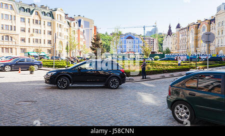 KIEV, UCRAINA - 5 Maggio 2017: auto e persone sulla piazza di Vozdvizhenka Street nel nuovo quartiere residenziale di antica area storica Gonchary Kozhemya Foto Stock