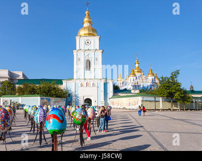 KIEV, UCRAINA - 5 Maggio 2017: persone e decorate le uova di Pasqua su St Michael's Square e vista di Saint Michael's Golden-Domed monastero nella città di Kiev. Foto Stock