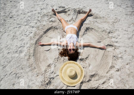 Elevato angolo di visione della donna di sabbia di angelo a spiaggia sulla giornata di sole Foto Stock