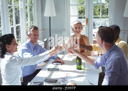 Gruppo di dirigenti la tostatura bicchieri di champagne nel ristorante Foto Stock