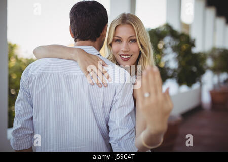 Ritratto di donna felice che mostra l'anello di innesto al ristorante Foto Stock