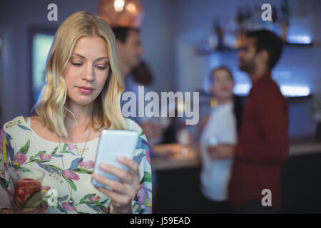 Bella donna utilizzando il telefono cellulare presso il bar ristorante Foto Stock