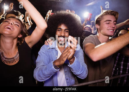 Ritratto di giovane uomo tra la folla godendo al nightclub Foto Stock