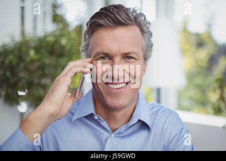 Ritratto di imprenditore parlando al telefono cellulare in ristorante Foto Stock