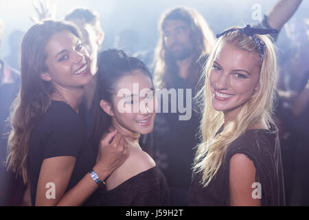 Ritratto di giovane donna amici godendo al nightclub Foto Stock