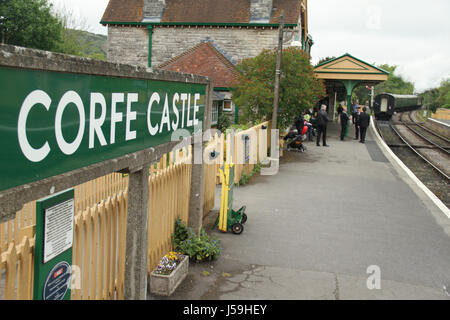 Swanage, Regno Unito - 12 Maggio: Swanage guardie ferroviaria e la stazione master chat sulla piattaforma a Corfe Castle stazione dopo la partenza delle 14.00 ore di treno a Norden. Vista generale di ​the cittadina balneare di ​Swanage​ nel Dorset, Inghilterra.​ © David Mbiyu/Alamy Live News Foto Stock