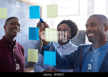 Positivo lavoro africana ai colleghi il brainstorming insieme in un ufficio Foto Stock