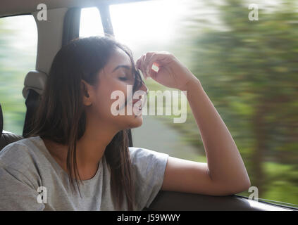 Bella giovani donne in auto capelli viene soffiata dal vento Foto Stock