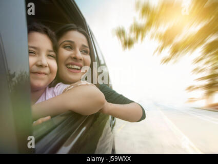 Felice madre e figlia a guardare fuori dalla finestra per auto Foto Stock