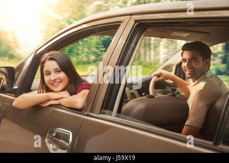 Coppia giovane di equitazione in auto a guardare fuori dalla finestra per auto Foto Stock