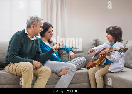 Nipote a suonare la chitarra con i suoi nonni Foto Stock