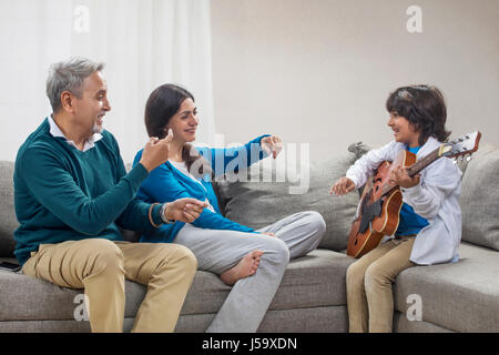 Nipote a suonare la chitarra con i suoi nonni Foto Stock