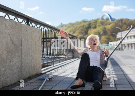 Disturbato donna sdraiata su lastre sulla banchina Foto Stock