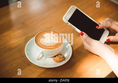Vista dall'alto latte art caffè sul tavolo di legno. Foto Stock