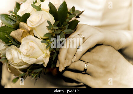 Sposa e lo sposo mani vicino fino ad anelli e fiori Foto Stock