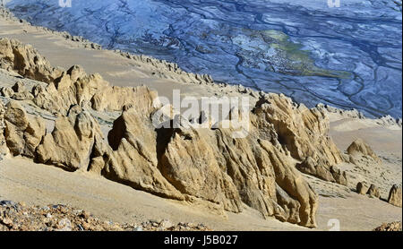 Canyon in alta montagna: alla ribalta il giallo di montagna di sabbia con la pietra di idoli e dietro il blu riverbed con numerosi torrenti, Tibet, India. Foto Stock
