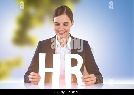 Donna che guarda le lettere H e R contro alberi contro il cielo blu e chiaro sulla giornata di sole Foto Stock