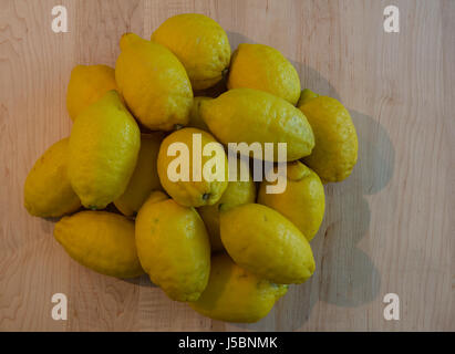 Una pila di limoni organico su una tavola di legno Foto Stock