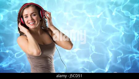 Digital composito di donna felice ascoltando musica sulle cuffie contro la riflessione della luce solare in acqua Foto Stock