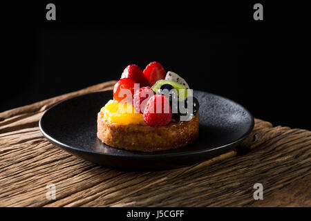 Frutta fresca tortino seduto su una tavola in legno rustico. Foto Stock