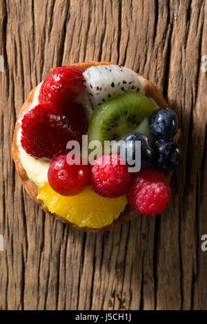 Frutta fresca tortino seduto su una tavola in legno rustico. Foto Stock