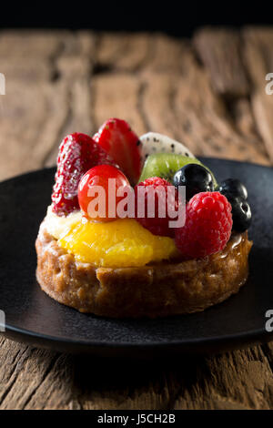 Frutta fresca tortino seduto su una tavola in legno rustico. Foto Stock