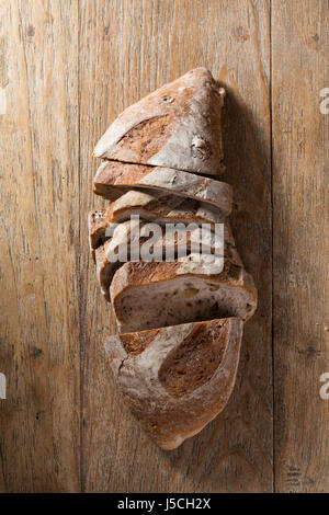 Vista al di sopra di un rustico della pagnotta di pane su un vecchio tavolo di legno. Foto Stock