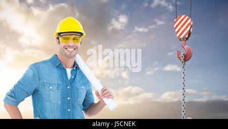 Composito Digitale di sorridere architetto azienda blueprint dal gancio della gru Foto Stock