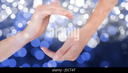 Composito Digitale di immagine ritagliata delle mani contro incandescente bokeh di fondo Foto Stock