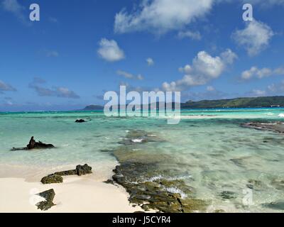 Acqua cristallina rotoli nelle spiagge di sabbia bianca e coralli di Managaha Island Foto Stock