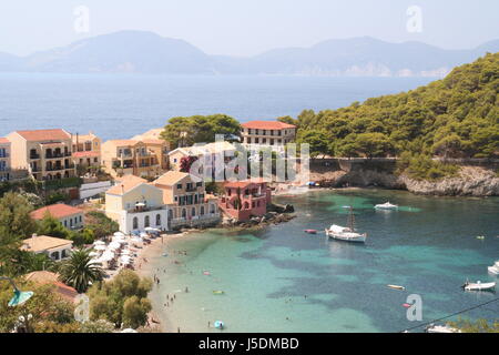 La bellissima e tranquilla località di Assos su uno stretto istmo di terra con baia riparata e spiaggia dell'isola greca di Cefalonia. Foto Stock