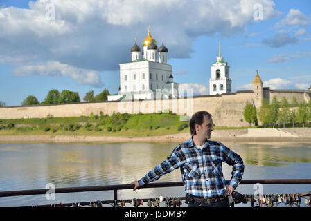 Un giovane uomo sorge sul ponte di osservazione sullo sfondo della Trinità nella cattedrale di Pskov Foto Stock