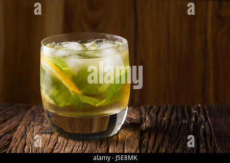 Un mojito cocktail seduti su un rustico bar in legno. Foto Stock