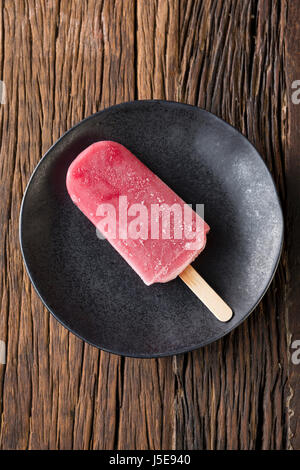 In casa di lamponi e gelato alla vaniglia pop su un legno rustico sfondo. Berry icecream ghiaccioli. Estate cibo. Foto Stock