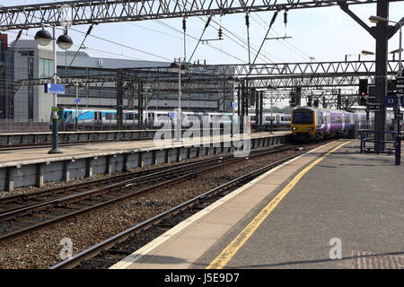 Due locali treni arrivano alla stazione ferroviaria di Manchester Piccadilly. Foto Stock