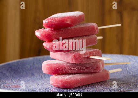 In casa di lamponi e gelato alla vaniglia pop su un legno rustico sfondo. Berry icecream ghiaccioli. Estate cibo. Foto Stock