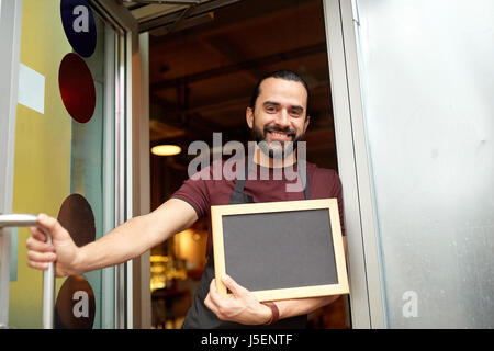 Uomo o cameriere con blackboard presso il bar porta di ingresso Foto Stock