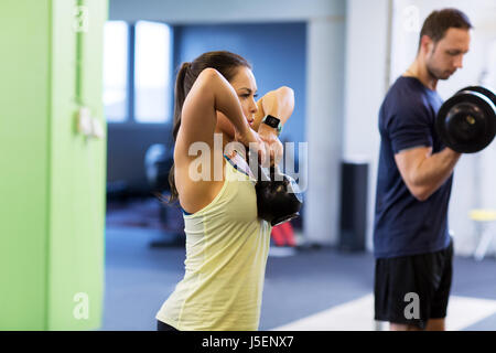 Uomo e donna con kettlebell esercizio in palestra Foto Stock