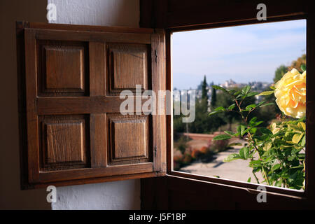 Vista sul paesaggio estivo attraverso la vecchia finestra con otturatore in legno Foto Stock