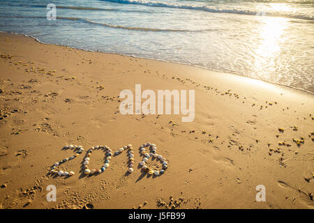 2018 Anno Nuovo testo realizzato utilizzando conchiglie sulla sabbia a Glenelg Beach Foto Stock