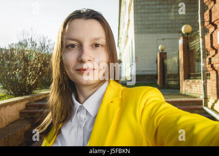 Ragazza giovane prendere selfie dalla mano su estate città street. La vita urbana concetto Foto Stock